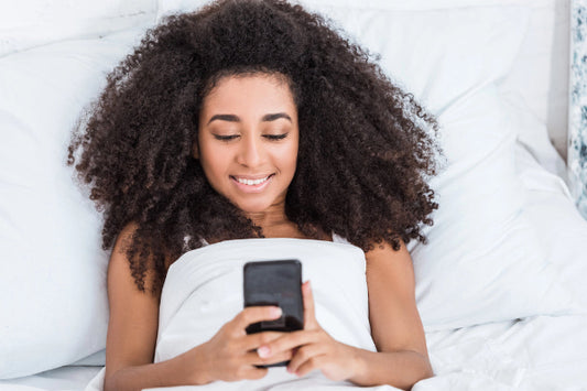 Woman using a smartphone on a bed